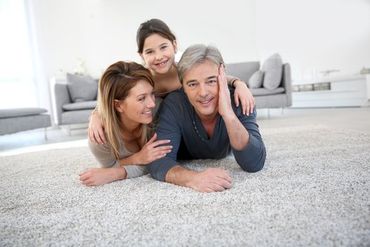 Happy family laying on twist pile carpet flooring in Sussex