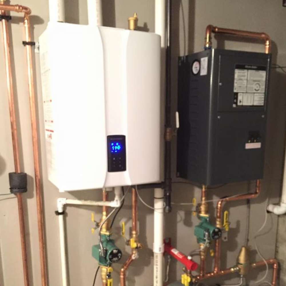 two water heaters are connected to copper pipes in a room