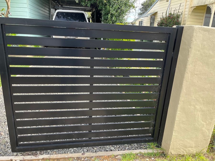 A Black Metal Fence in Front of Car — Newcastle & MidCoast Privacy Screens & Gates In Kurri Kurri, NSW