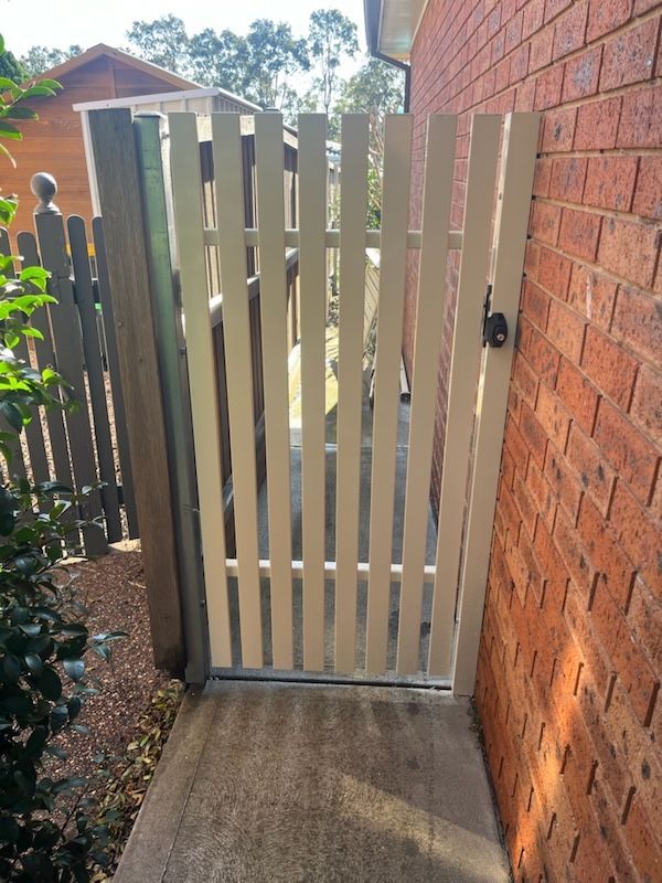 A White Fence with a Lock on it — Newcastle & MidCoast Privacy Screens & Gates In Kurri Kurri, NSW