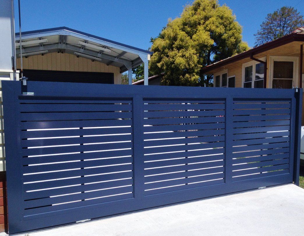 A Blue Sliding Gate is in Front of a House — Newcastle & MidCoast Privacy Screens & Gates In Kurri Kurri, NSW