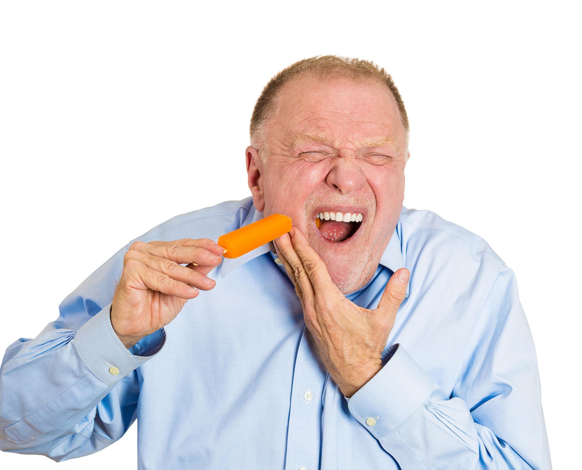 A man in a blue shirt is holding a carrot in his mouth.