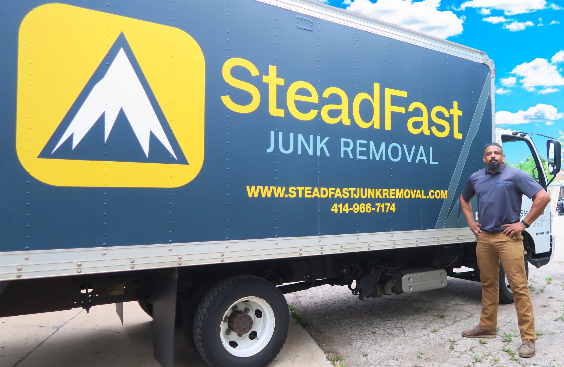 A man standing in front of a SteadFast junk removal truck in Milwaukee, Wisconsin.