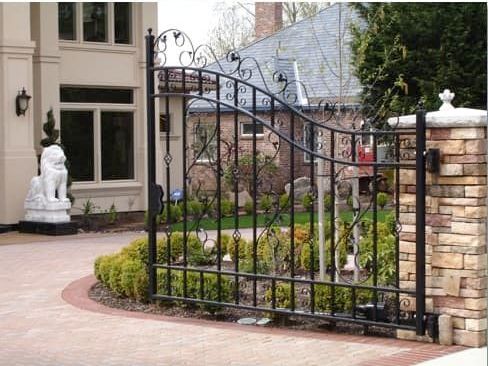 A wrought iron gate is in front of a house