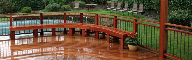 A wooden deck with a bench and a fence around it