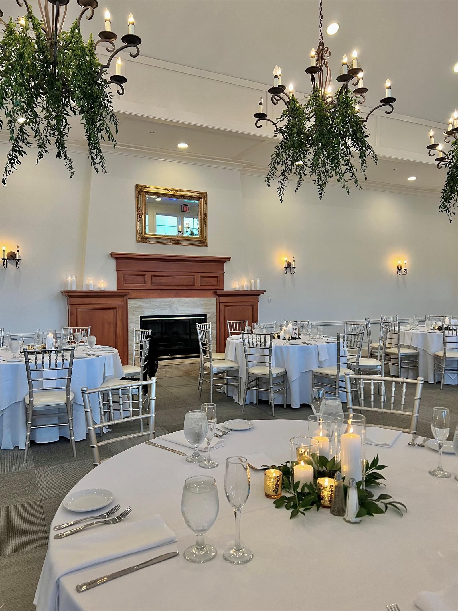 A large room with tables and chairs set up for a wedding reception.