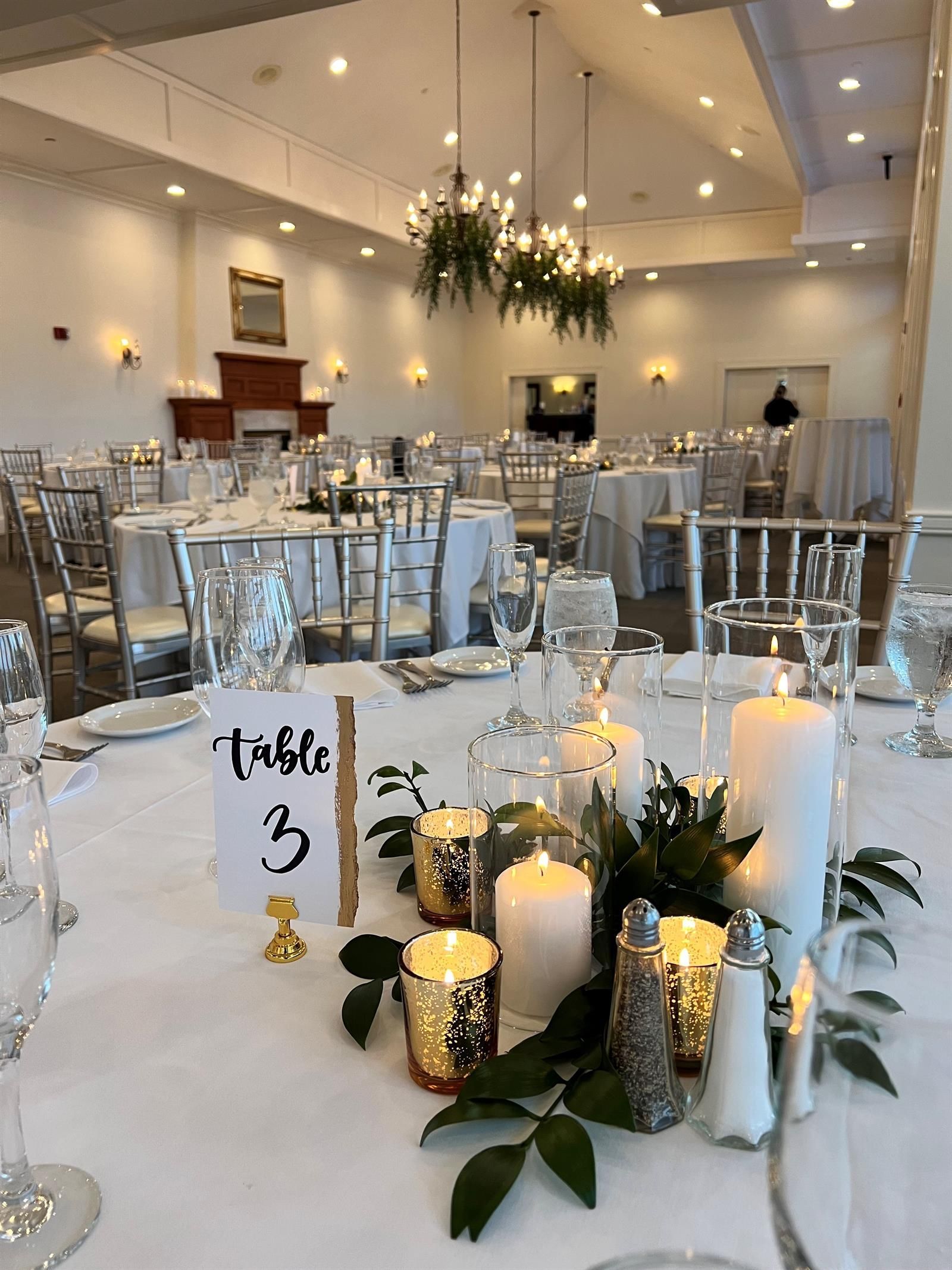 A large room with tables and chairs set up for a wedding reception.