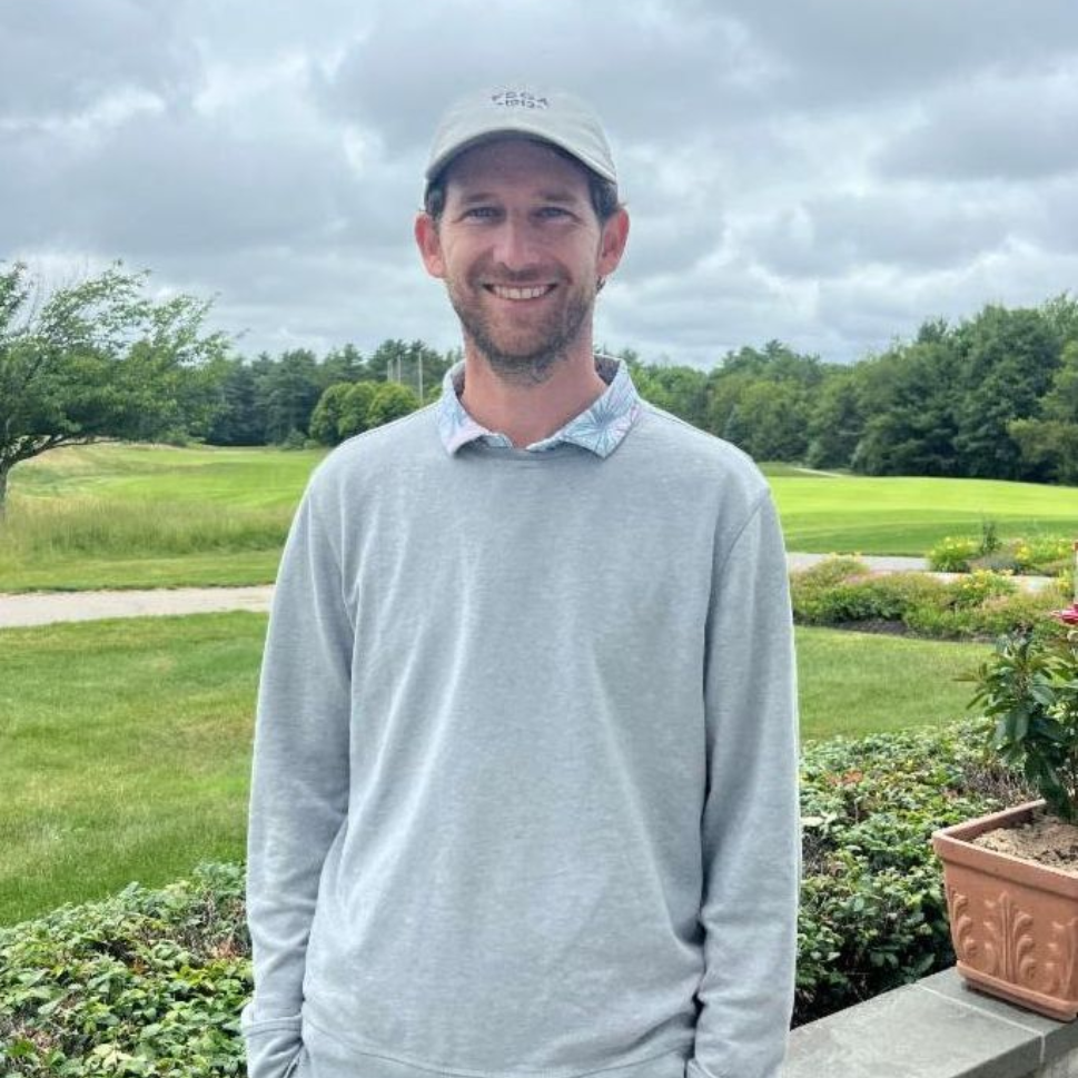 A man standing in front of a window wearing a jacket that says jacksonville