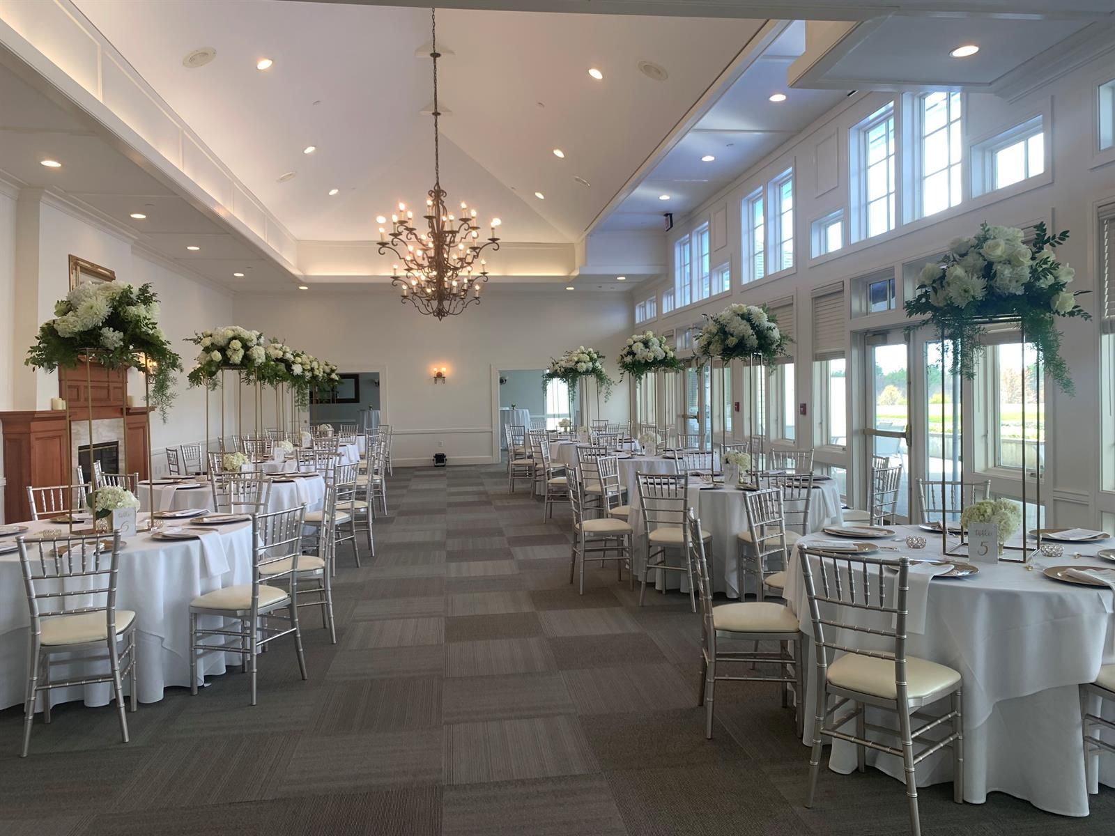 A large room with tables and chairs set up for a wedding reception.