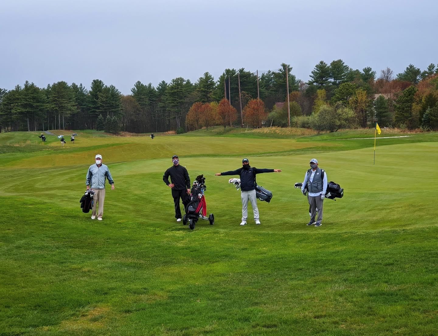 A group of people are standing on a golf course.