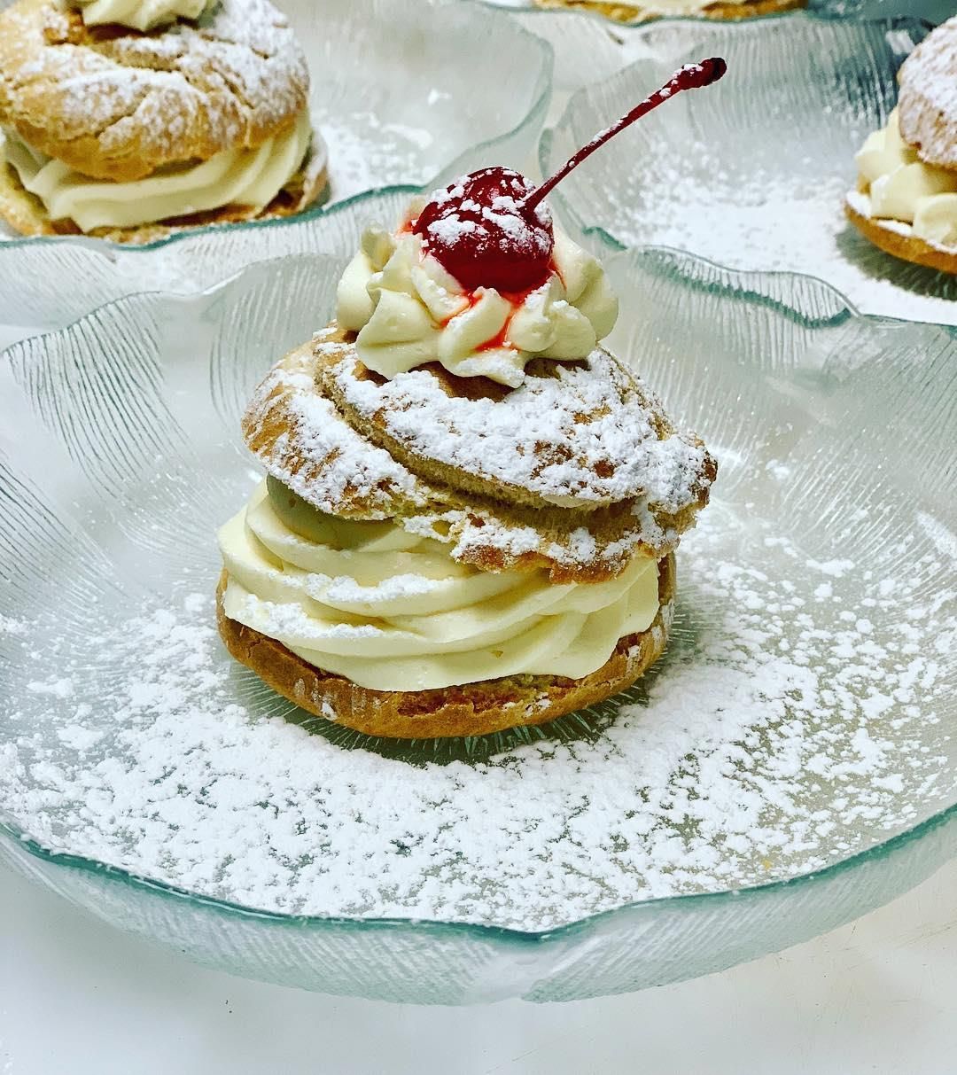 A dessert with powdered sugar and a cherry on top