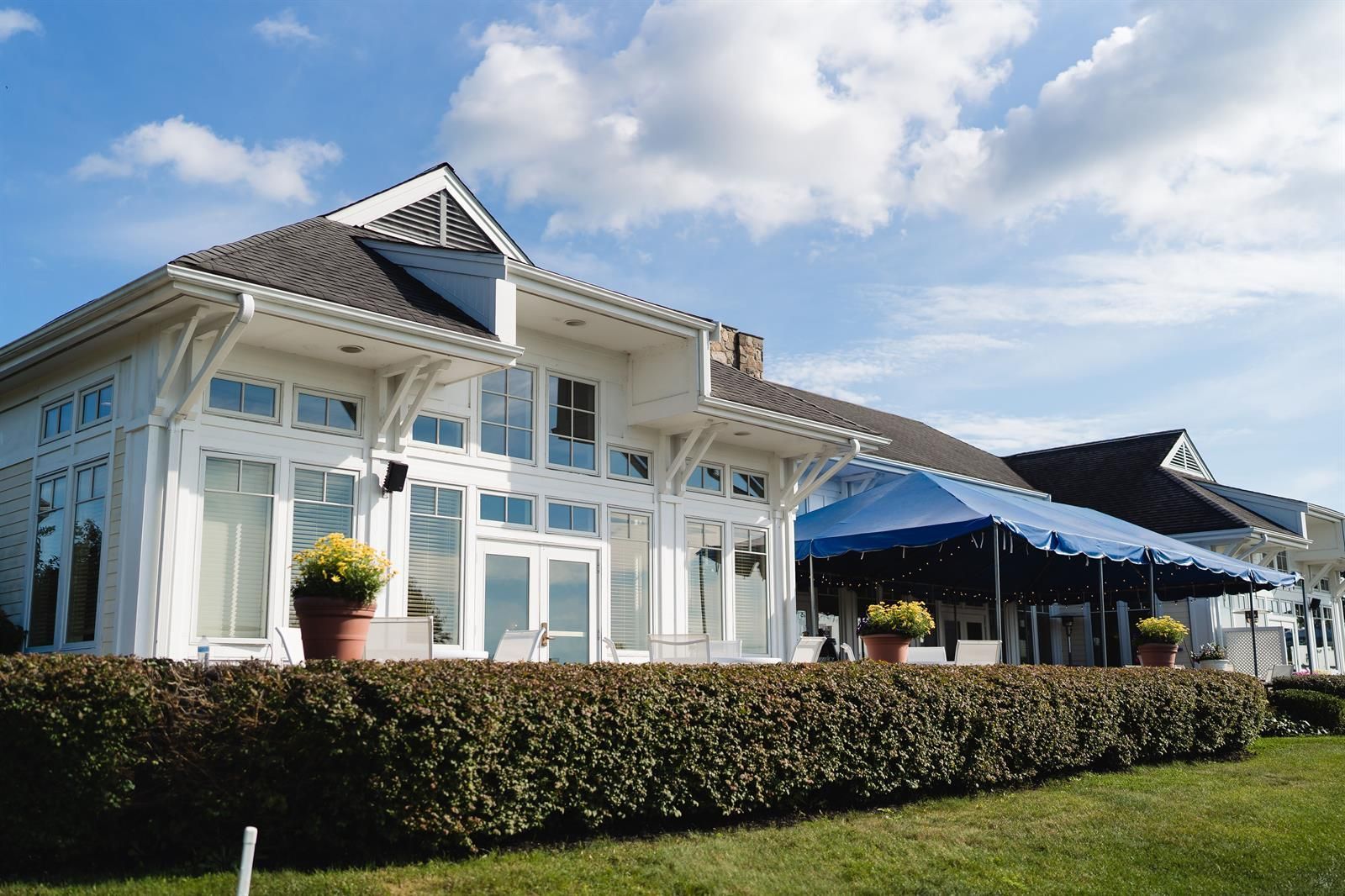 A large white house with a blue tent in front of it