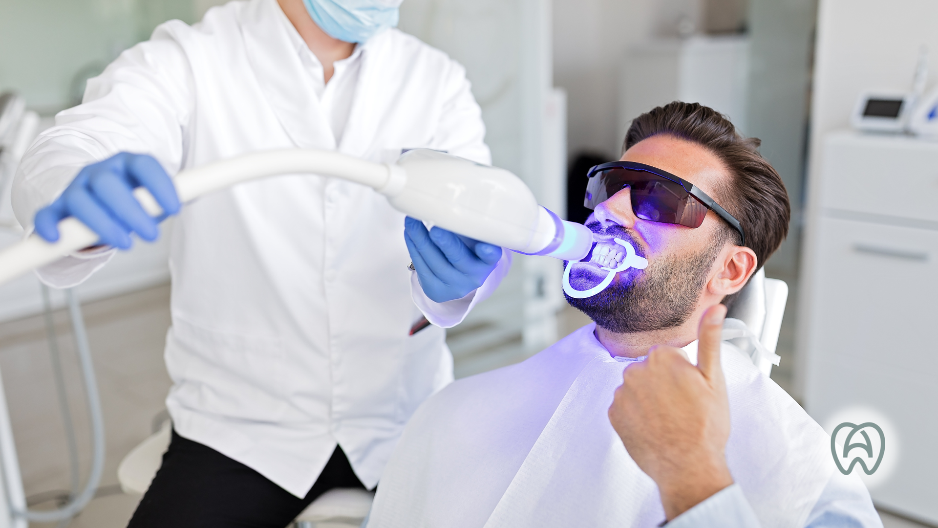 Person undergoing teeth whitening treatment with blue light, wearing protective glasses.