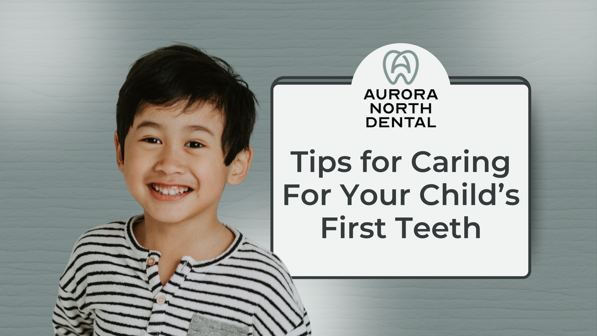 Young child smiles next to a sign that says
