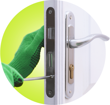 A Locksmith Expert with Green Gloves Is Installing A Hinged Handle Lock On A White Wooden Door.