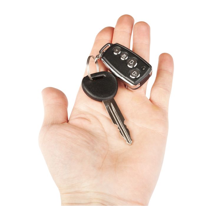 A Hand Holding A Transponder Key And A Remote Fob.
