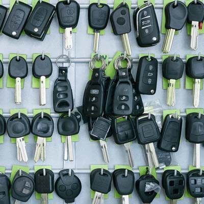 A Bunch Of Car Keys Are Hanging On A Wall.