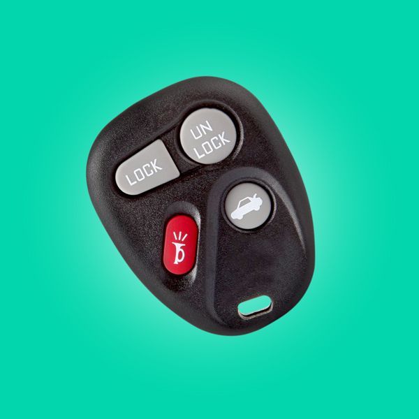 A Close Up Of A Remote Key Fob On A Green Background.