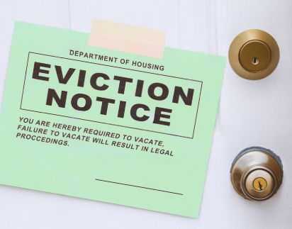 A Green Eviction Notice Is Taped To A Door.