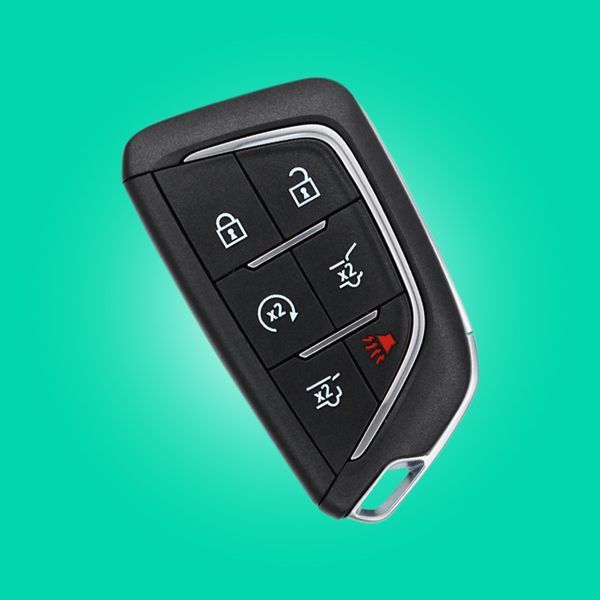 A Close Up Of A Smart Car Key On A Green Background.