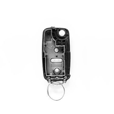 A Damaged Remote Control With A Key Ring Attached To It.