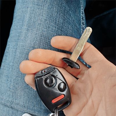 A Car Owner Holding A Broken Remote Head Key.