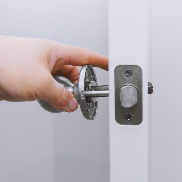A Professional Locksmith Is Installing A New Doorknob At Home.