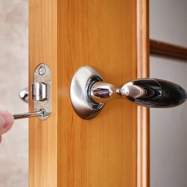 A Locksmith Installing A Lever Lock On An Office Door.