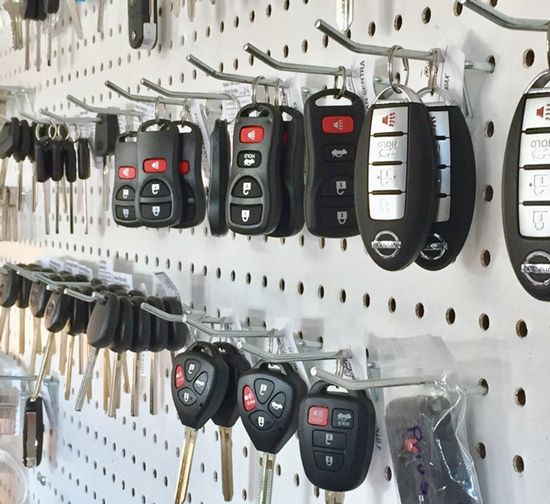 A bunch of car keys hanging on a wall.