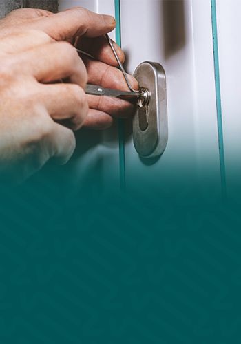 A Locksmith Technician Attempts To Open A Locked White Door Using Lock Picking Tools.