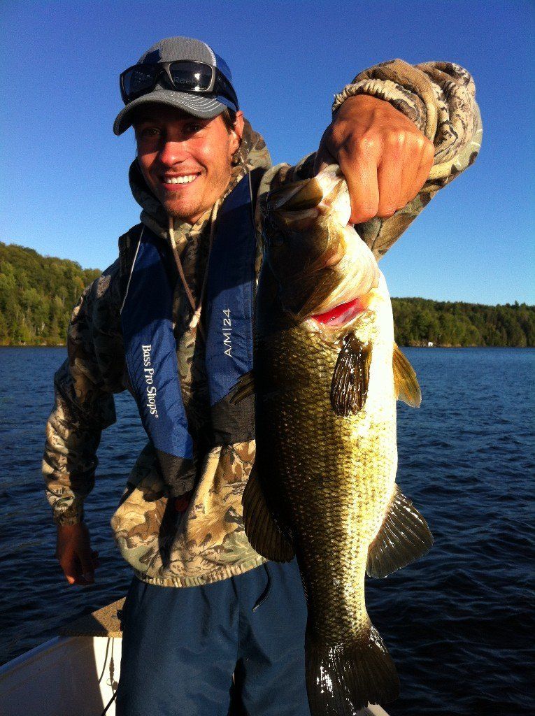 A man in a life vest holds a large fish