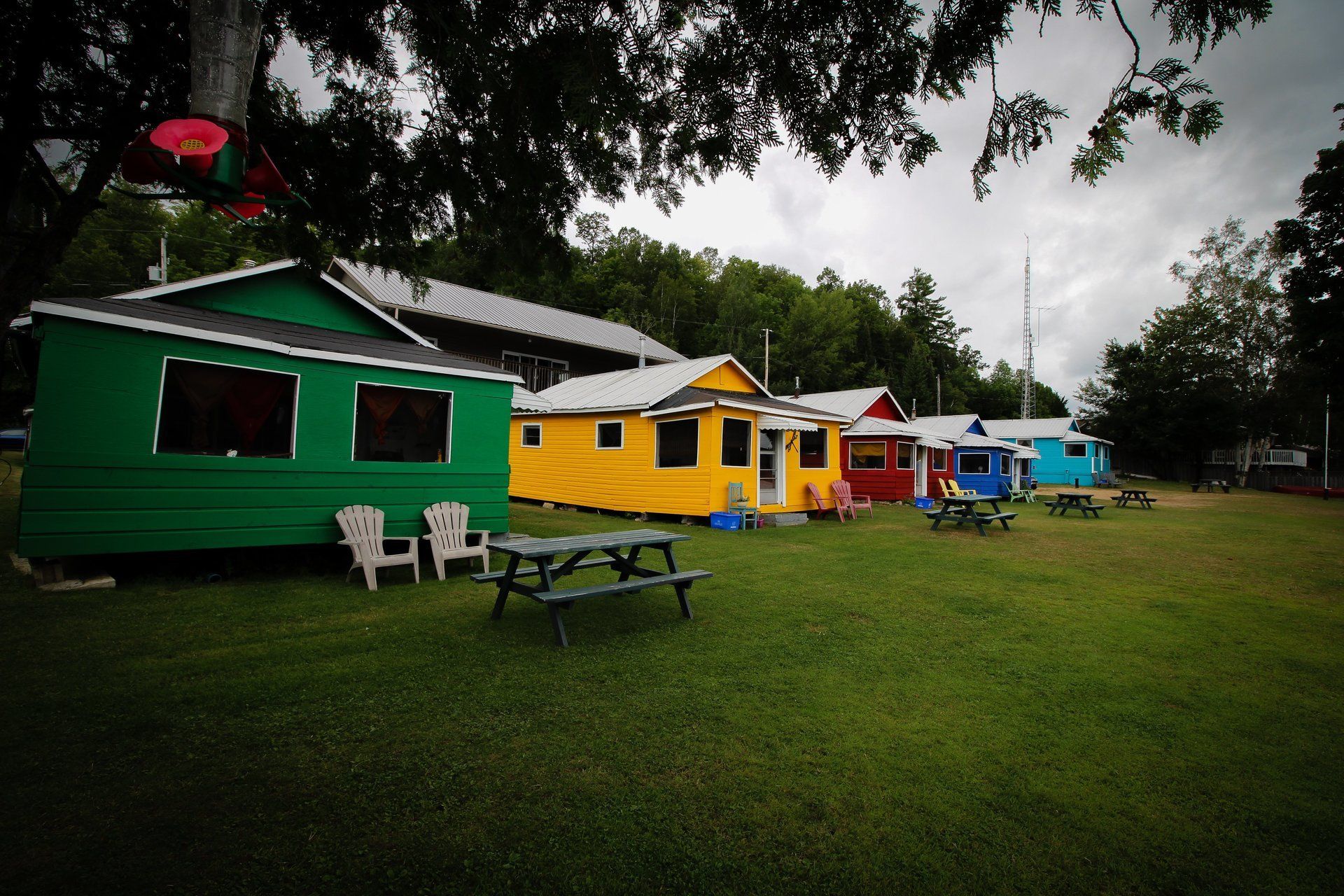 A row of colorful houses with picnic tables in front of them