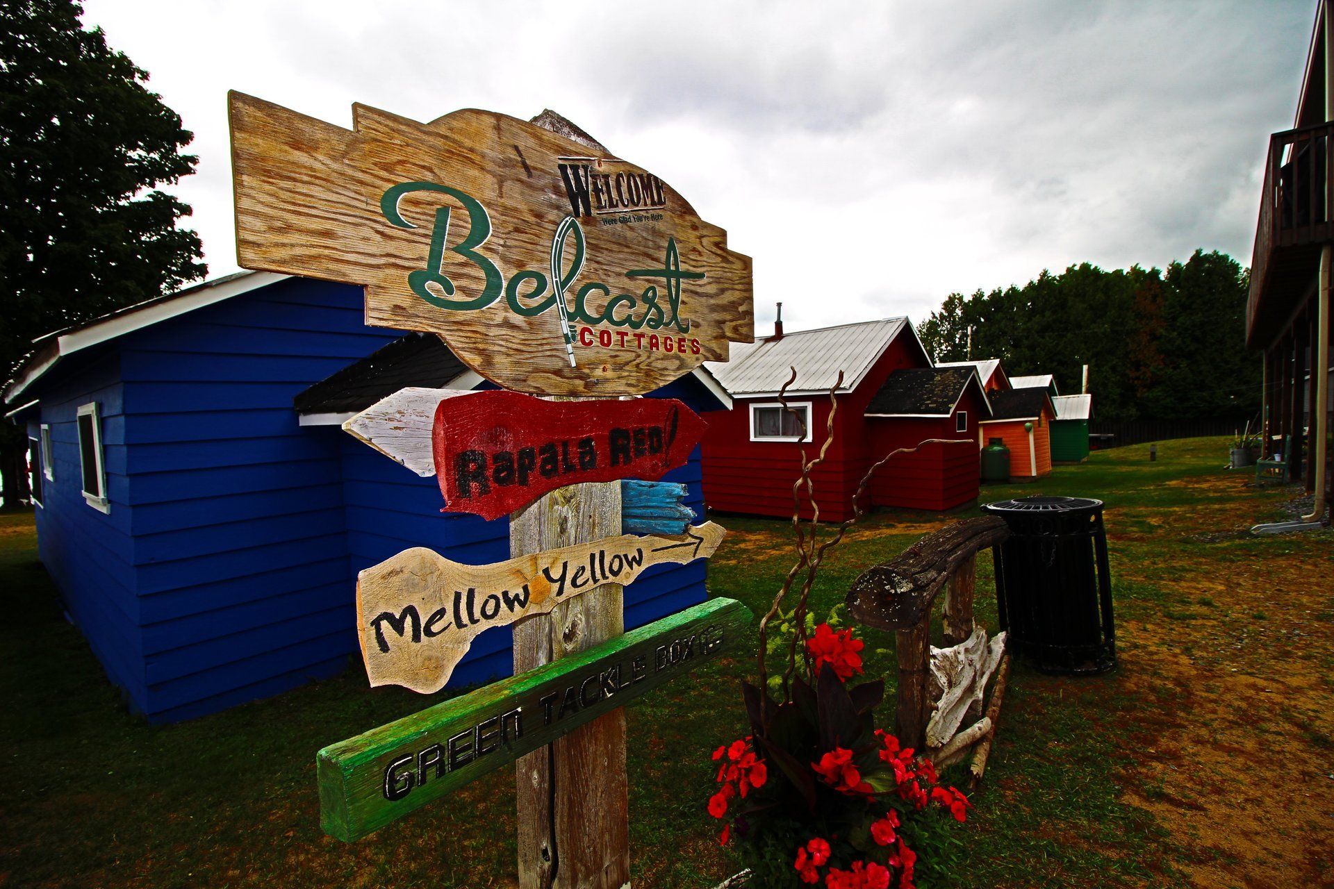 A sign in front of a blue building that says belcoast