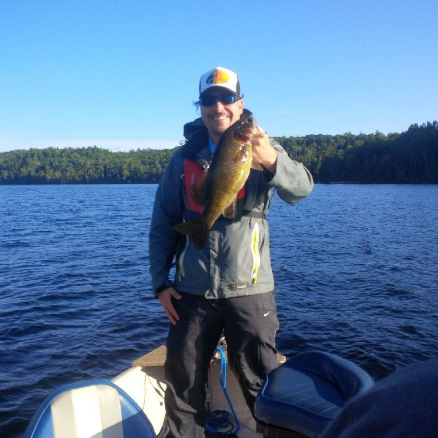 A man on a boat holding a fish in his hand