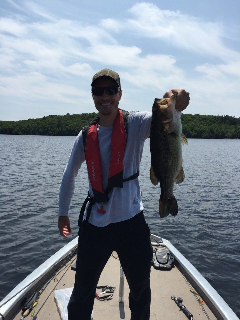 A man on a boat holding a large fish