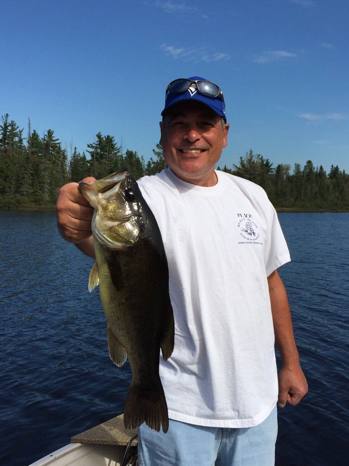 A man in a white shirt is holding a large fish
