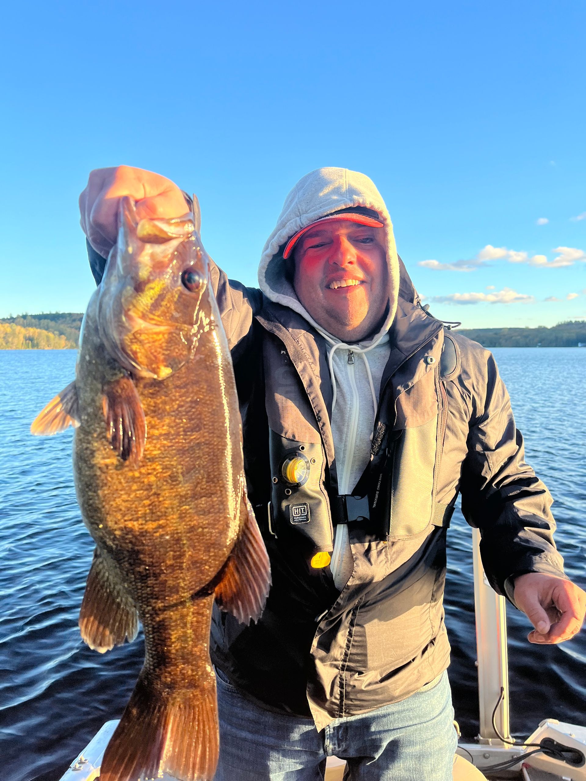 A man on a boat holding a large fish