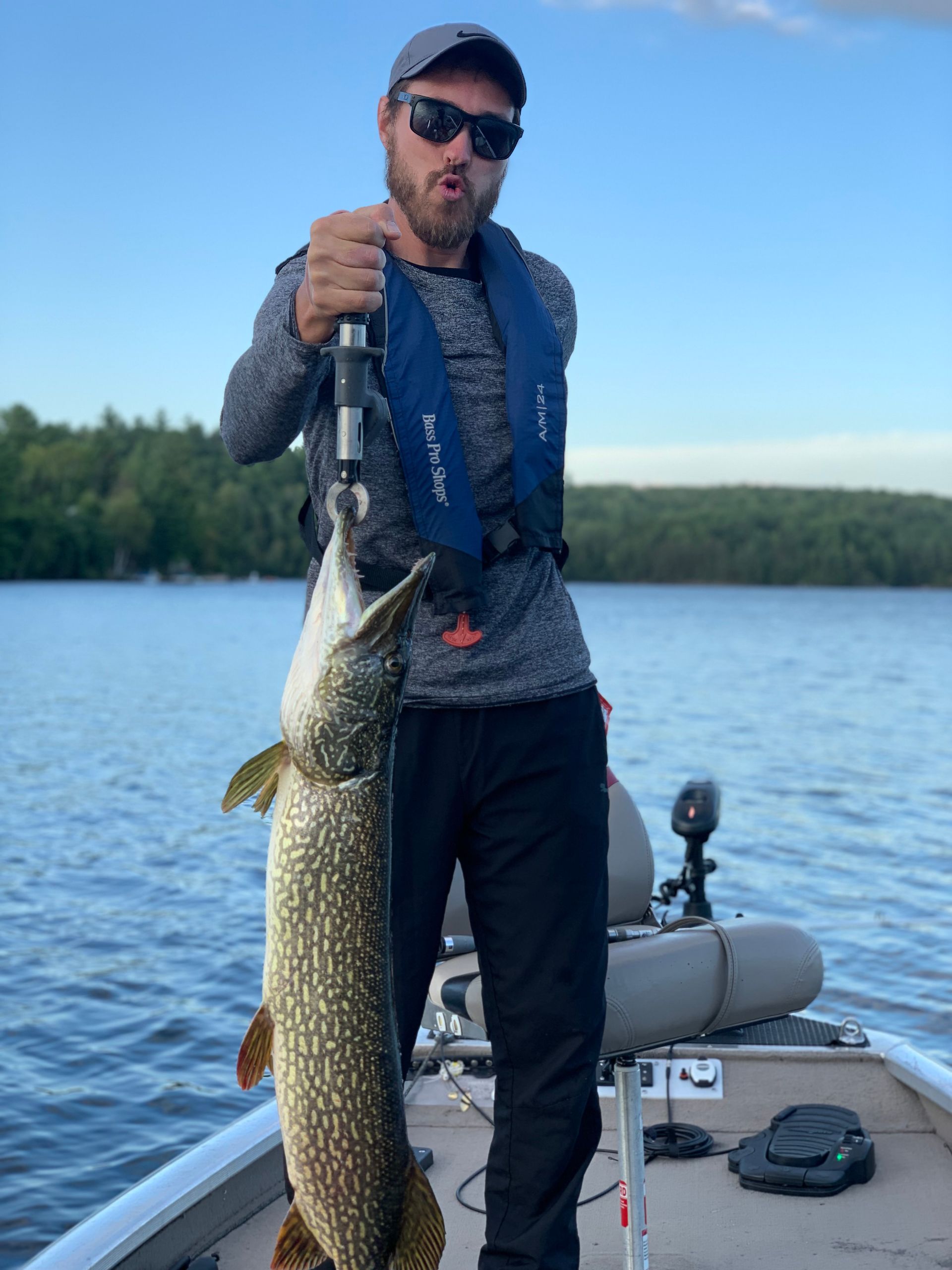 A man on a boat holding a large fish