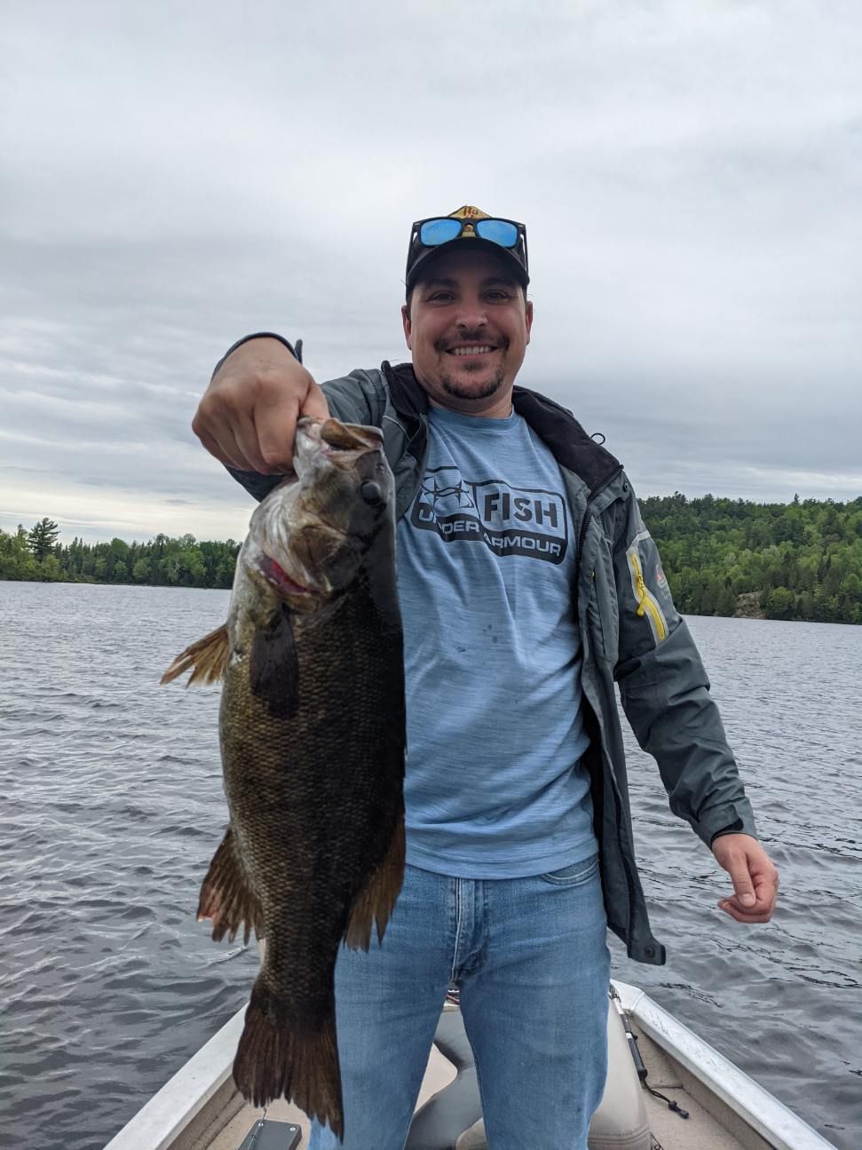 A man in a boat is holding a large fish