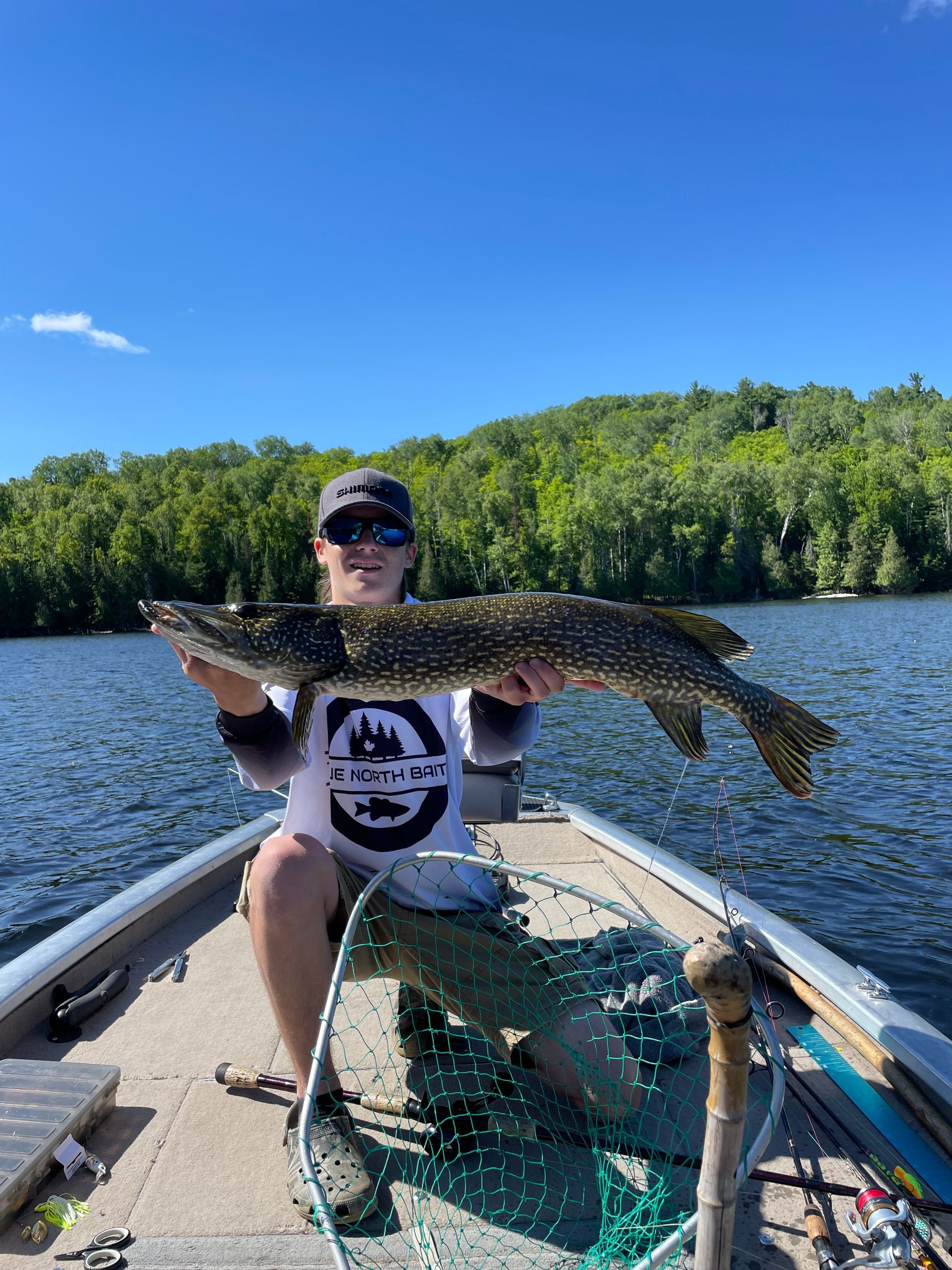 A man is sitting on a boat holding a large fish.