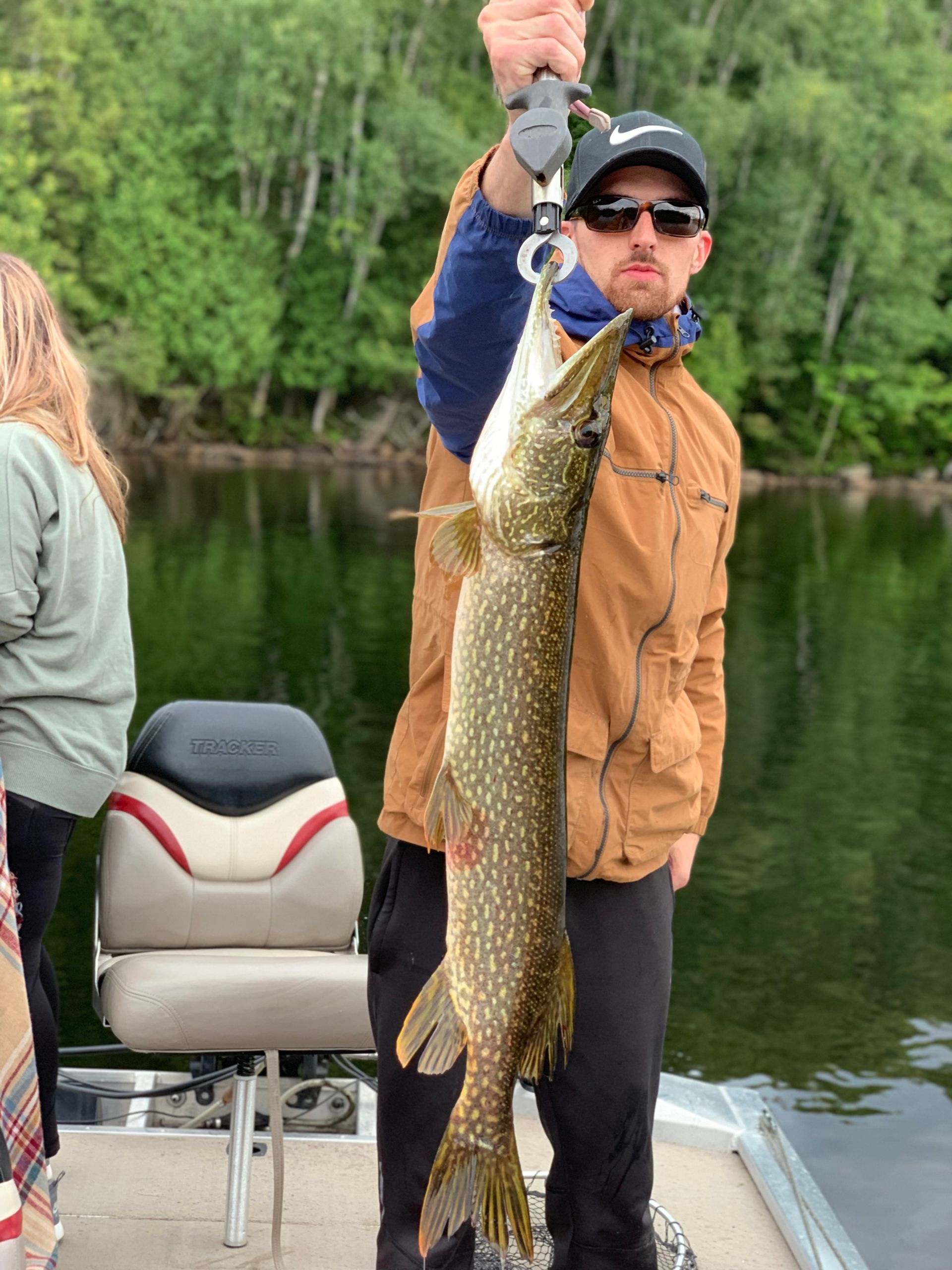 A man is holding a large fish on a boat.