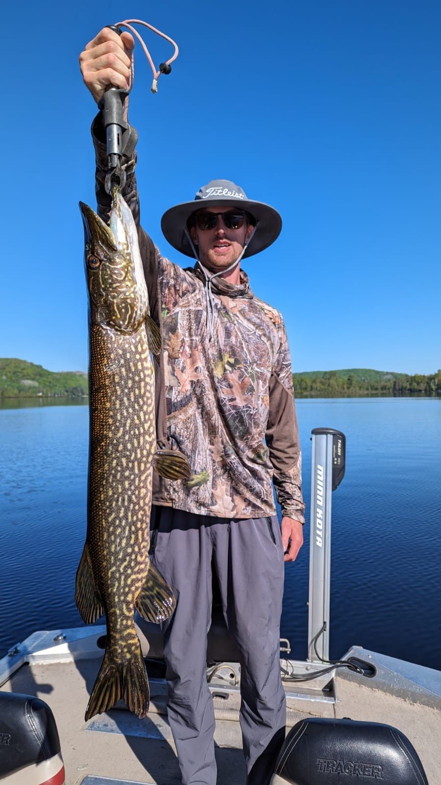 A man is holding a large fish on a boat.