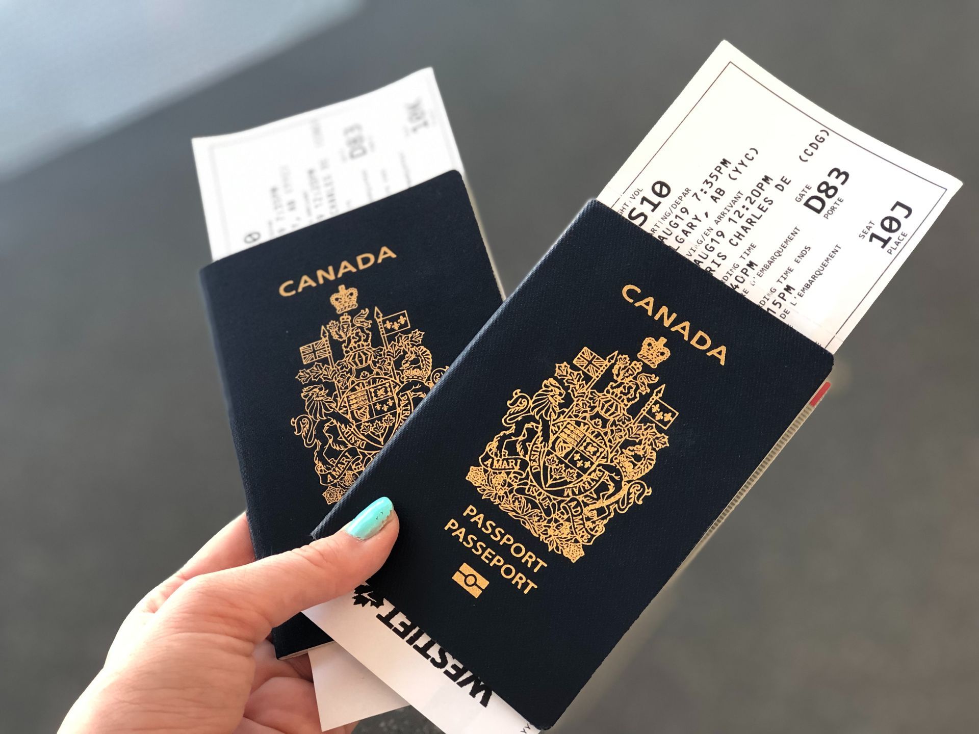 a person holding two canadian passports and boarding tickets