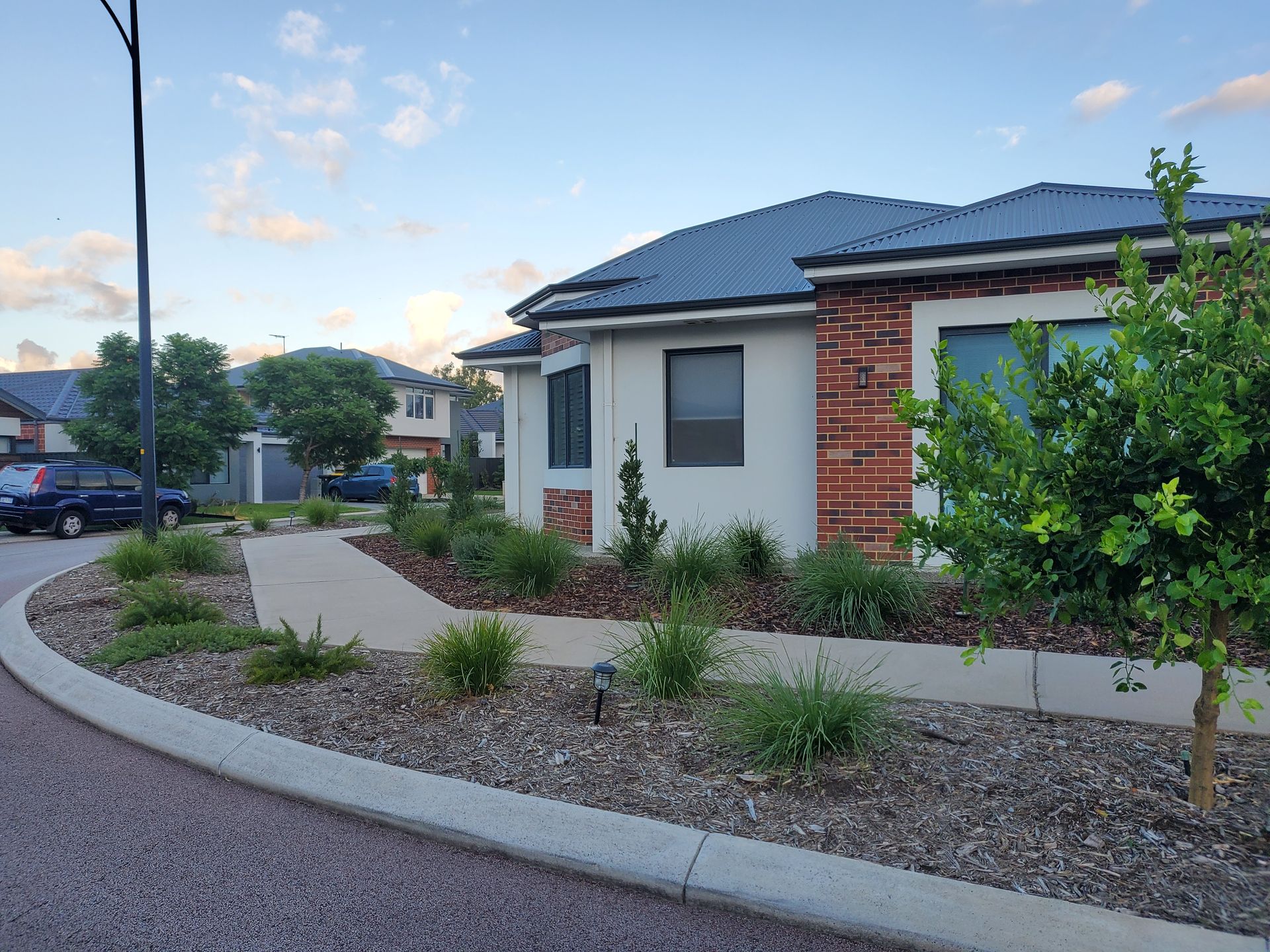 Suburban house with red brick accents, light stucco, and landscaping.