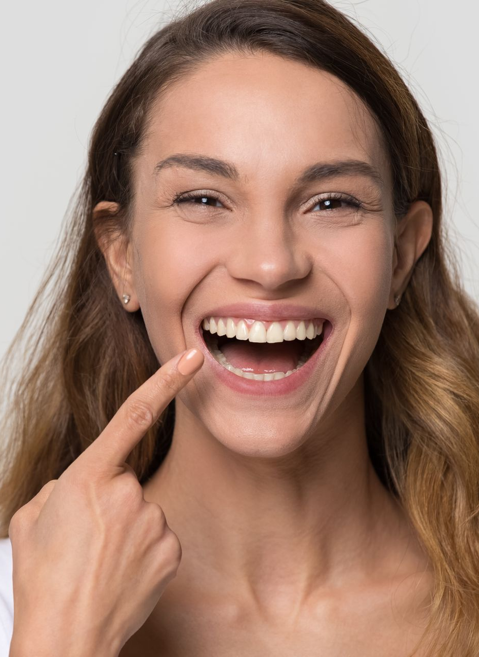 Smiling woman with radiant white teeth showcasing cosmetic dental services.