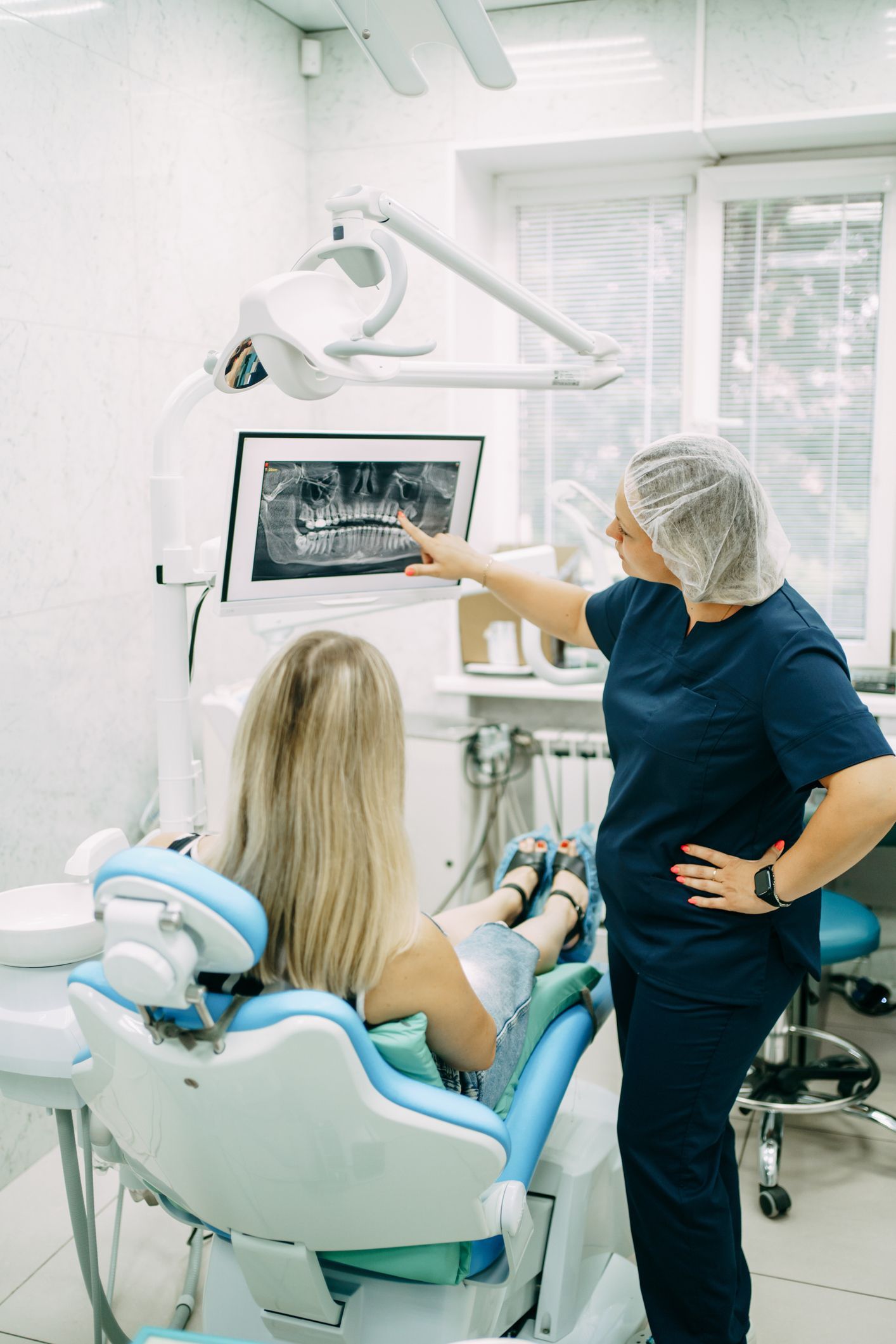 Orthodontist shows the patient an x-ray of the teeth and gives recommendations for treatment. Orthodontist shows the patient an x-ray of the teeth and gives recommendations for treatment.