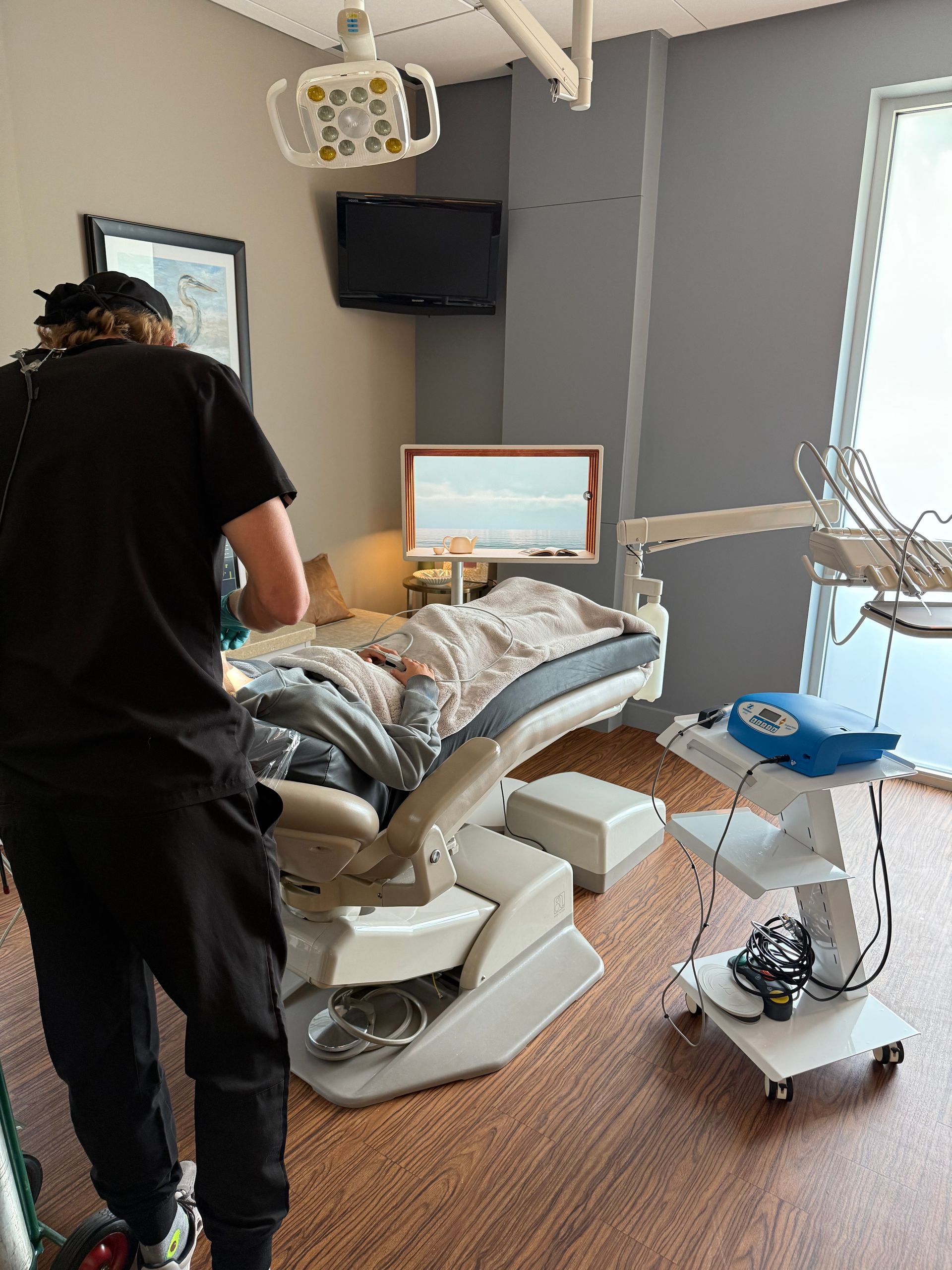 Woman with curly blonde hair smiles at the camera, against a pink background.