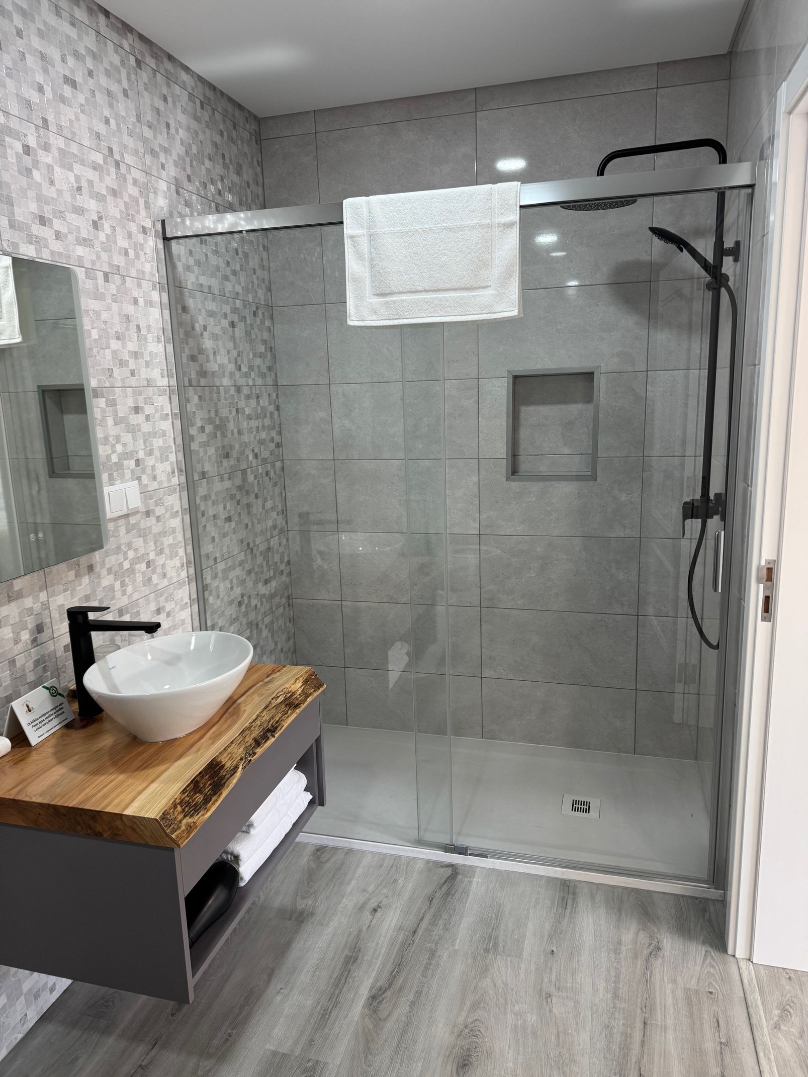 A bathroom with a sink and a walk in shower.