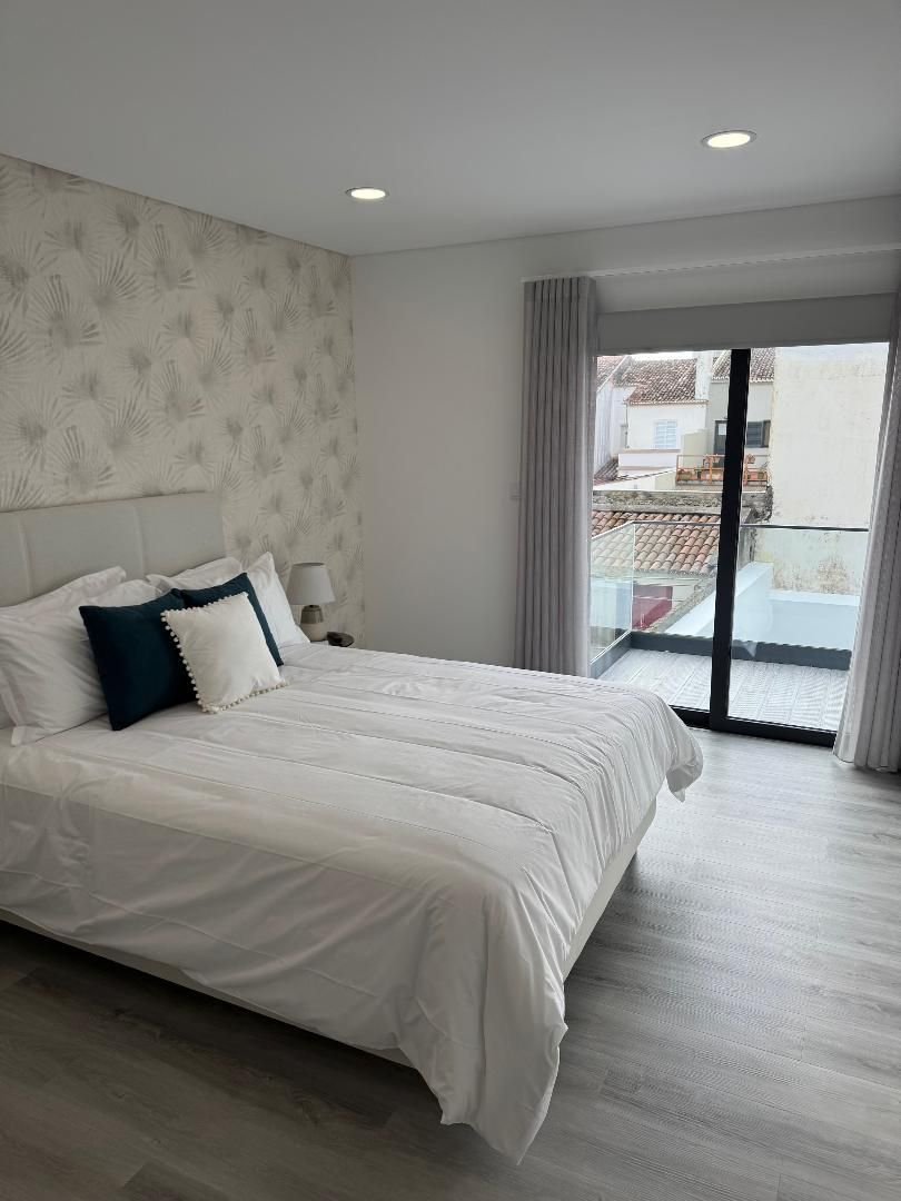 A bedroom with a large bed and a sliding glass door.