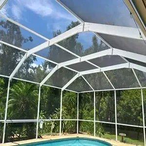 A group of professionals in a brick-walled office meeting around a table, listening as a person presents on a laptop.